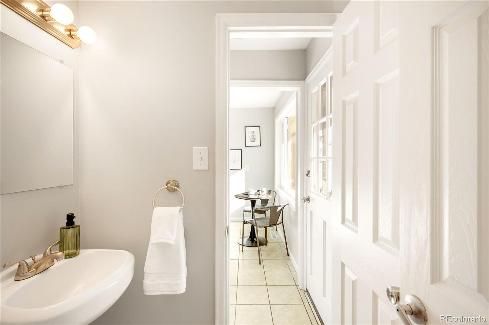 2438 South Perry Street Denver, CO 80219 - Photo 9 of 23 a en suite bathroom with a sink a mirror and a shower