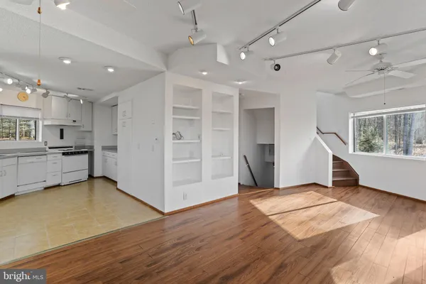 a kitchen that has a lot of white cabinets and stainless steel appliances