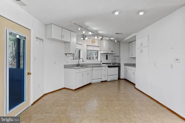 a kitchen with kitchen island white cabinets and chandelier