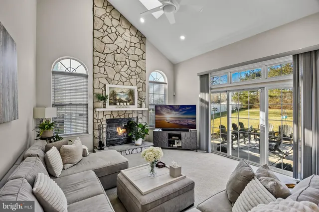 a living room with fireplace furniture and a floor to ceiling window