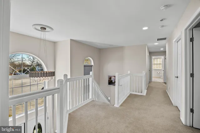 a view of a hallway with entryway and stairs
