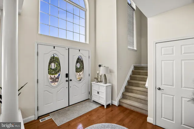 a view of a hallway with entryway wooden floor windows and entryway