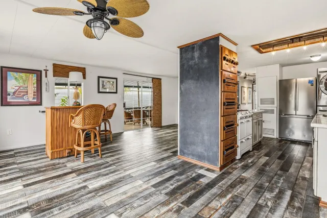 a view of a livingroom with furniture a ceiling fan and wooden floor