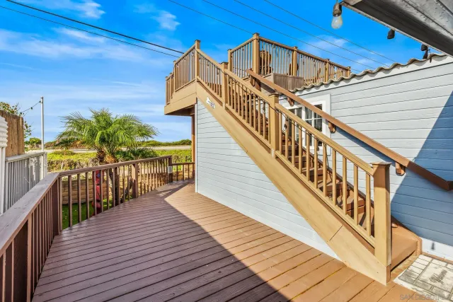 a view of balcony with wooden floor and fence