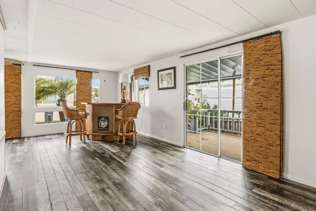 a view of a livingroom with wooden floor and furniture
