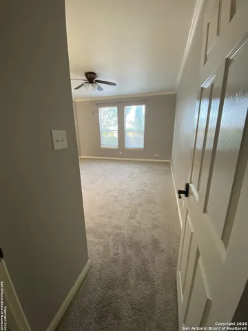 an empty room with windows and ceiling fan view