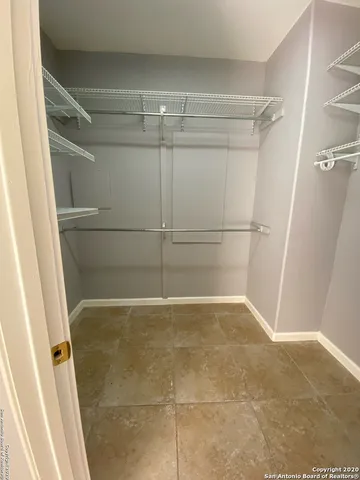 an empty room with wooden floor fireplace and windows