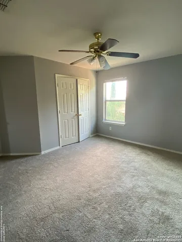 an empty room with windows and fan