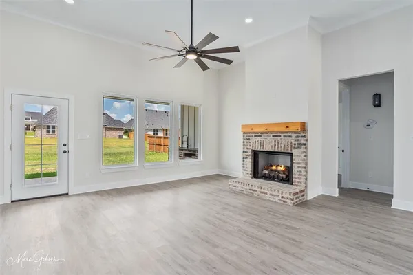 a view of an empty room with a window and fireplace
