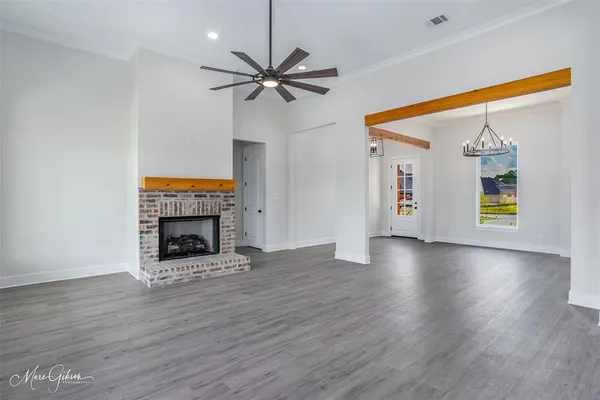 a view of an empty room with a fireplace and a window