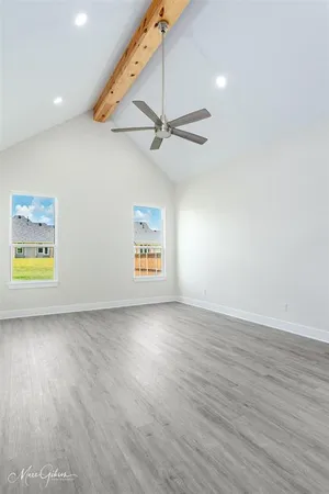 an empty room with wooden floor and ceiling fan