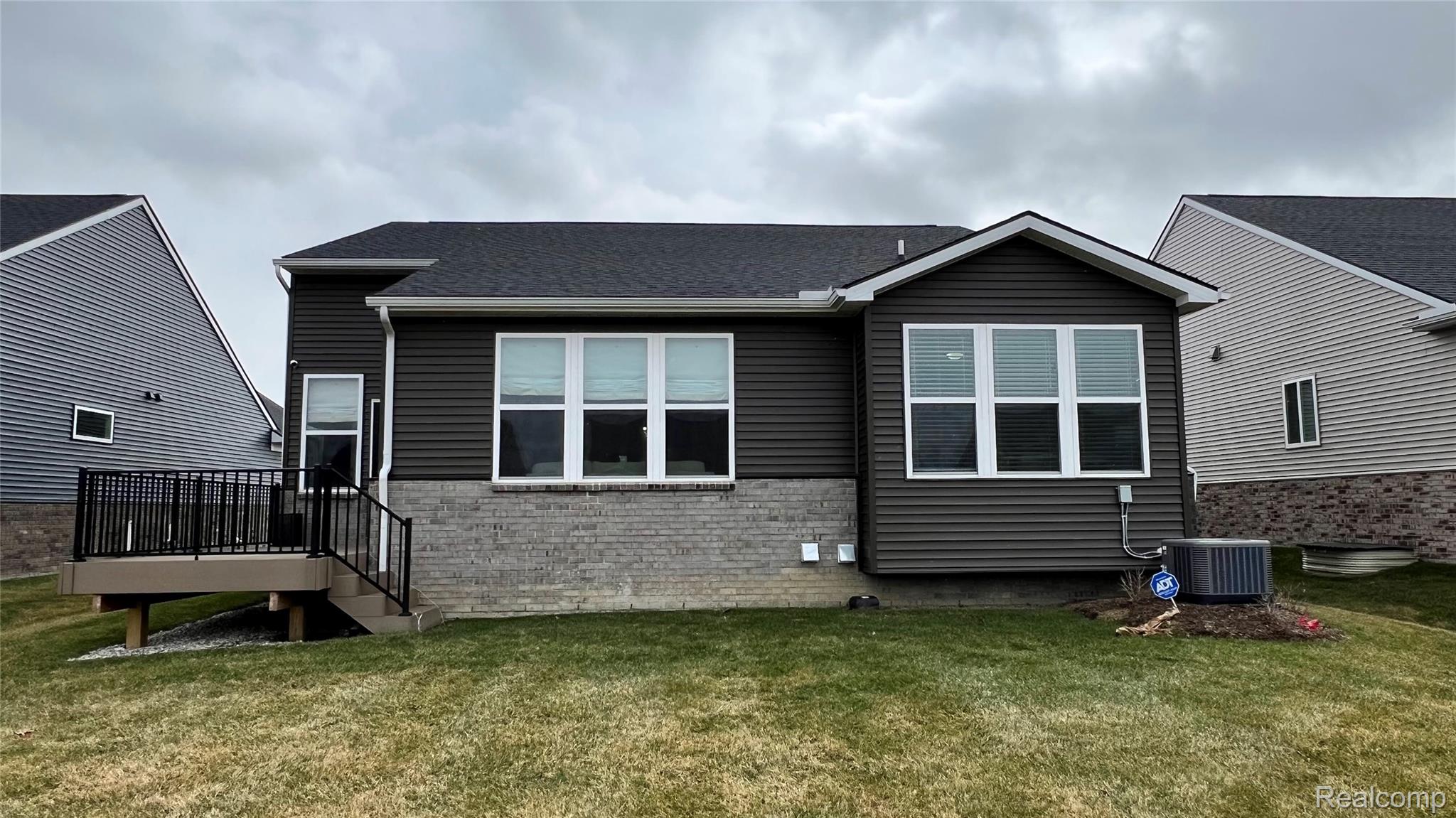 50192 Ogden Road Canton, MI 48188 - Photo 2 of 28 Back of house featuring a lawn, a deck, brick siding, and a shingled roof
