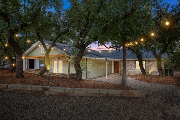 a front view of a house with a yard and trees