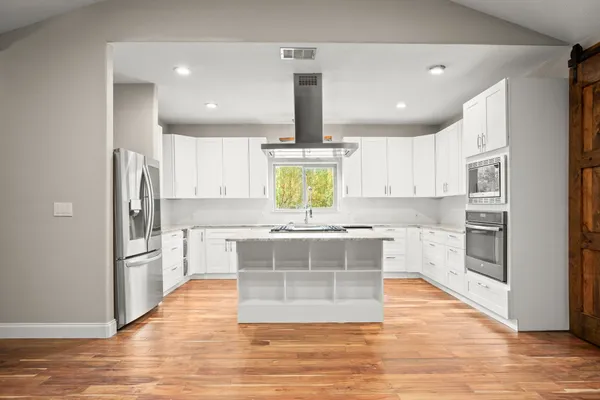 a kitchen with stainless steel appliances a stove top oven and refrigerator