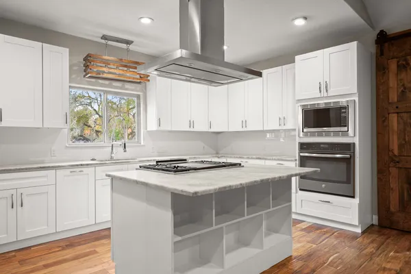 a kitchen with stainless steel appliances a stove a sink and a microwave