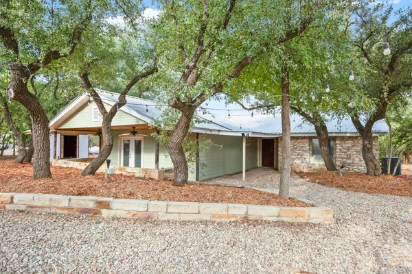 a front view of a house with a yard and an trees