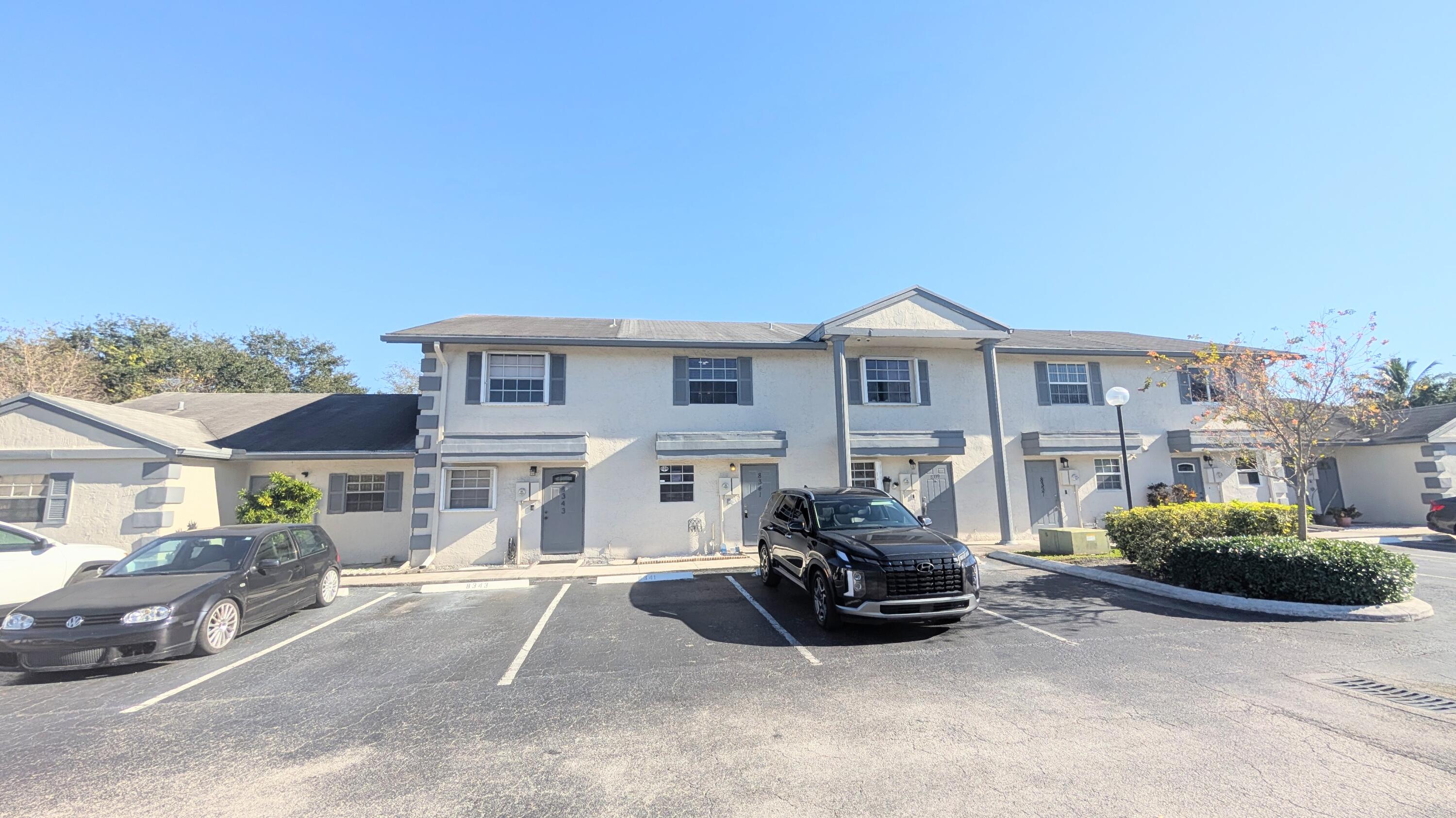a front view of a house with a garden and parking