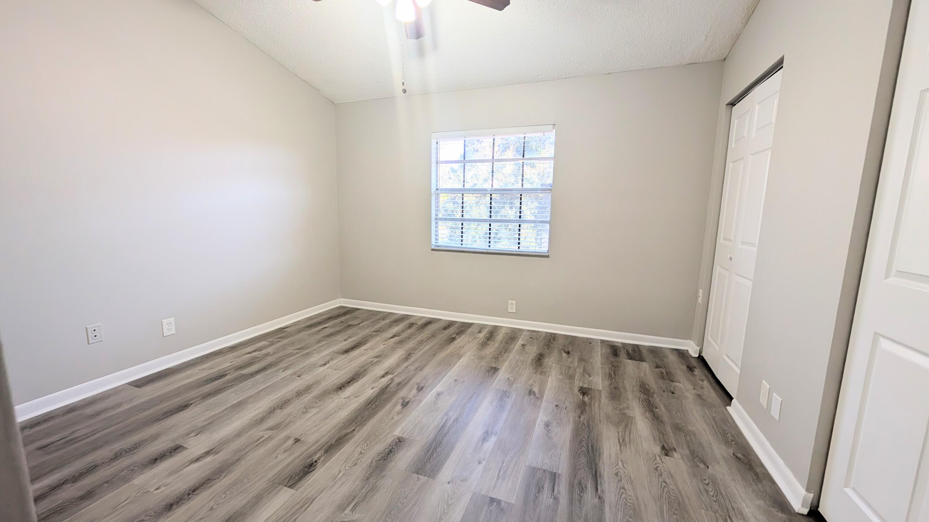 8341 Fairway Road Sunrise, FL 33351 - Photo 12 of 15 an empty room with wooden floor and windows