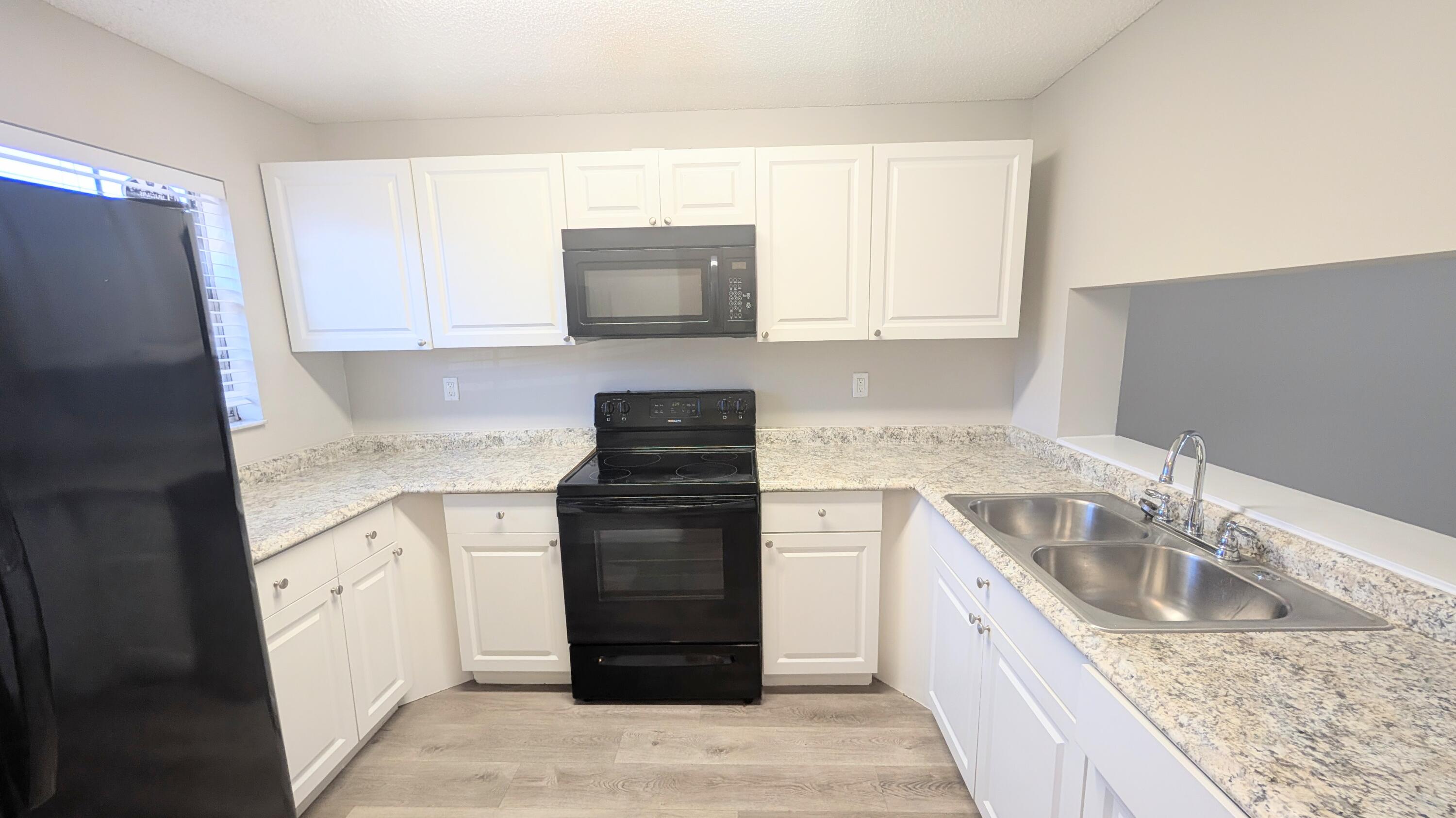 8341 Fairway Road Sunrise, FL 33351 - Photo 2 of 15 a kitchen with a sink stove and refrigerator