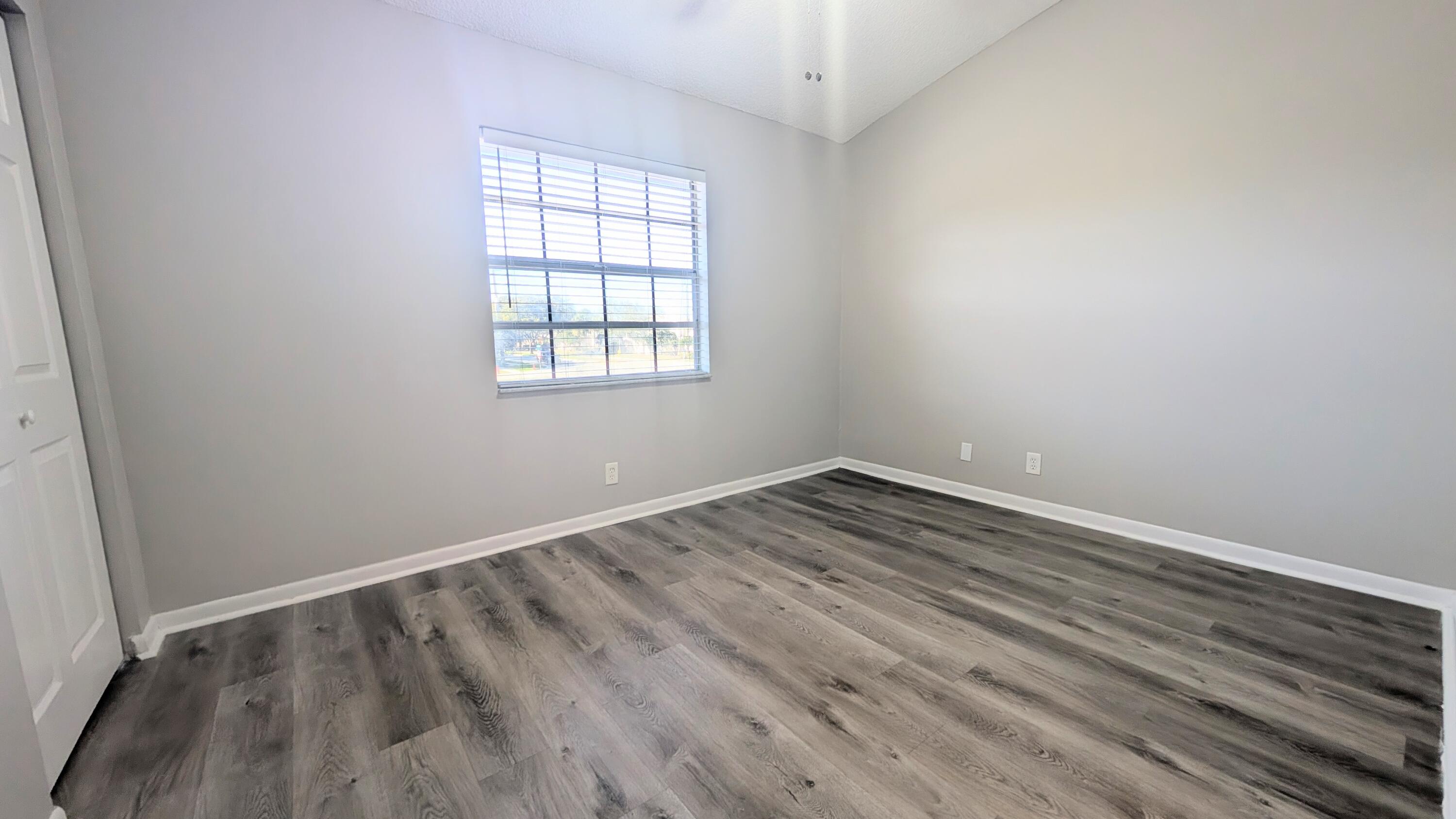 8341 Fairway Road Sunrise, FL 33351 - Photo 9 of 15 an empty room with wooden floor and windows