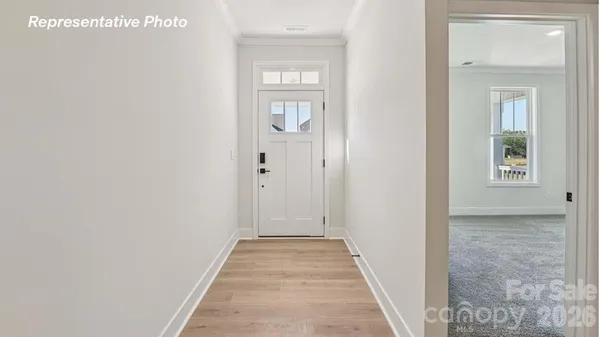 a view of a hallway with wooden floor and windows