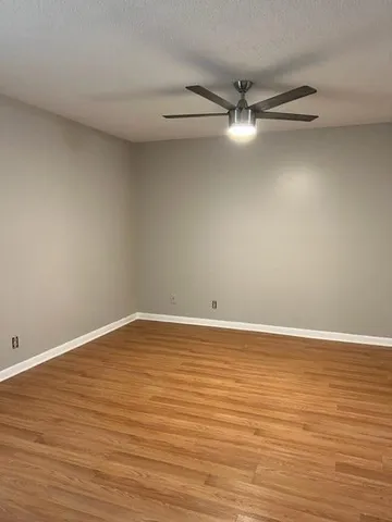a view of an empty room with wooden floor