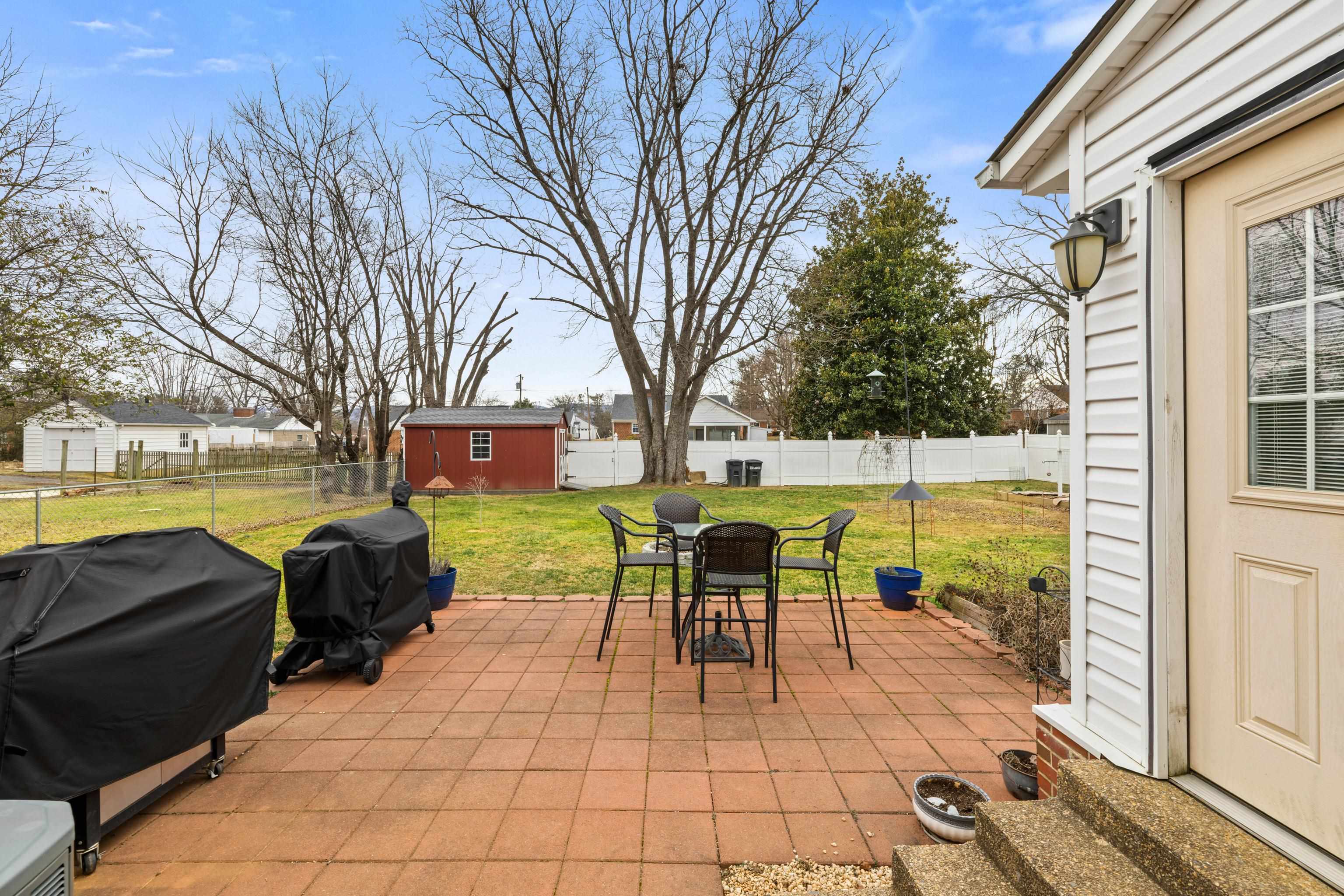 212 Alphin Avenue Waynesboro, VA 22980 - Photo 48 of 63 a view of a patio with dining table and chairs with wooden floor and fence