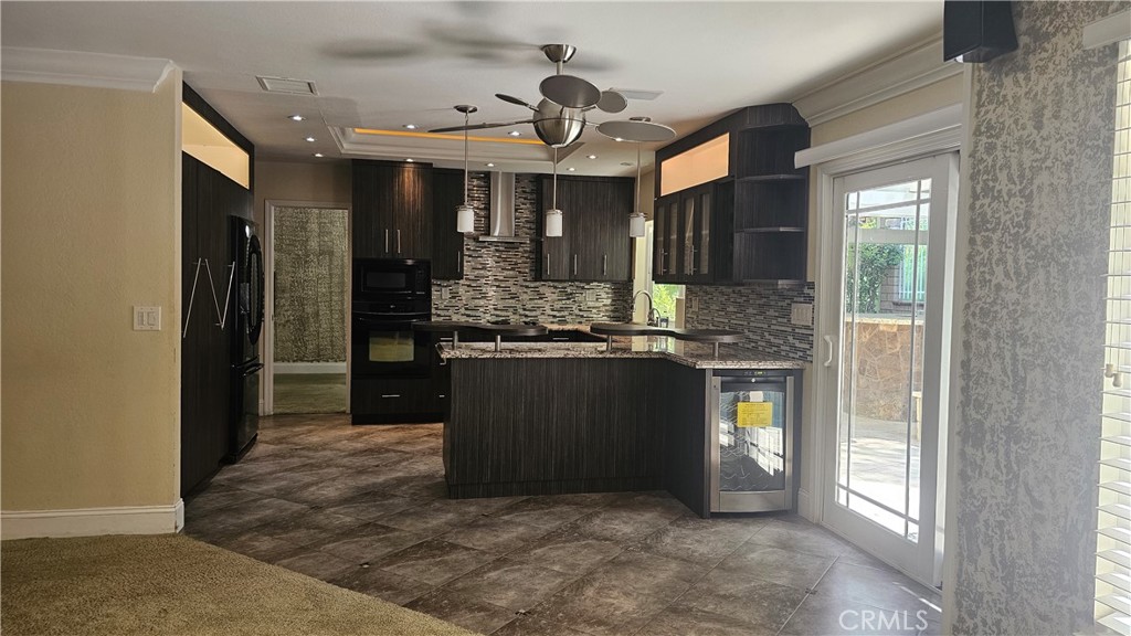 24722 Bracken Lane Stevenson Ranch, CA 91381 - Photo 27 of 36 a kitchen with kitchen island granite countertop a refrigerator and a sink