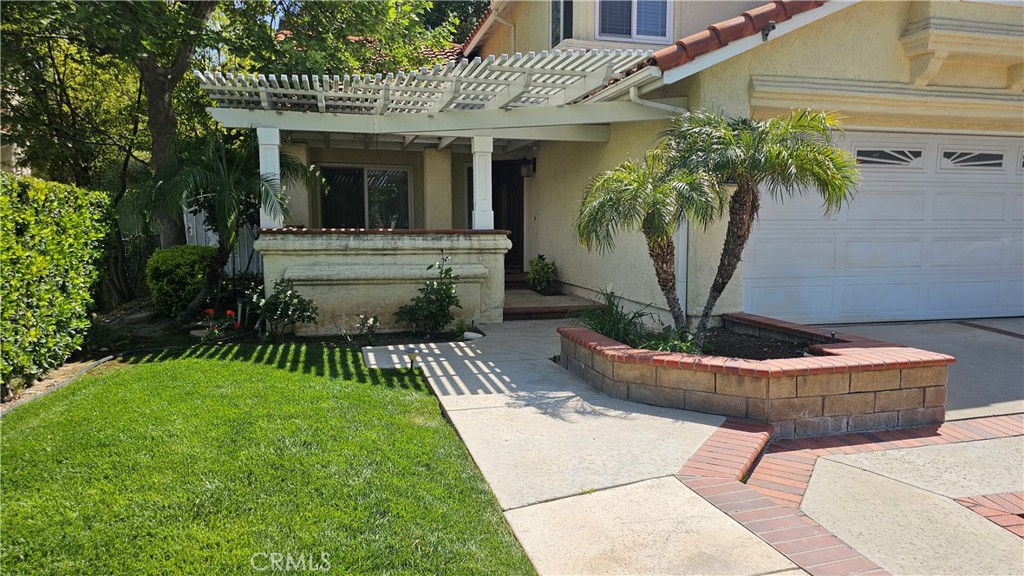 24722 Bracken Lane Stevenson Ranch, CA 91381 - Photo 3 of 36 a front view of a house with a garden