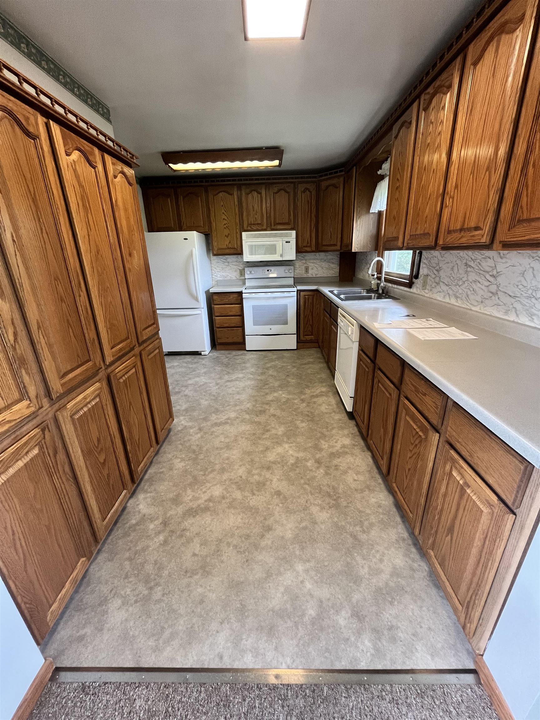 5047 Anderson Road Hermantown, MN 55811 - Photo 14 of 48 Kitchen featuring white appliances, brown cabinets, and light countertops