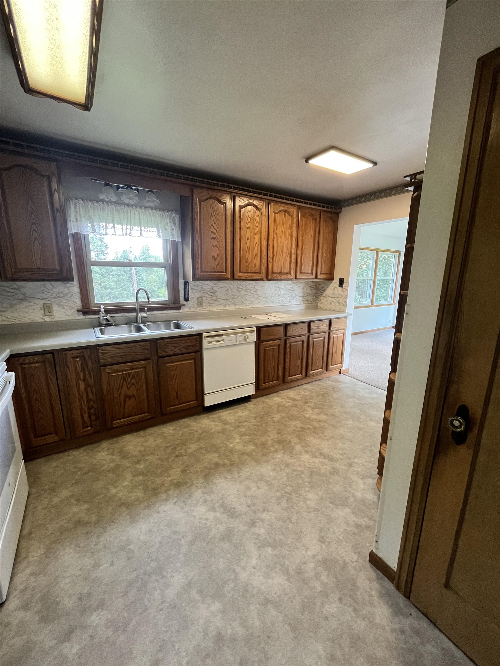 5047 Anderson Road Hermantown, MN 55811 - Photo 15 of 48 Kitchen with light countertops, white appliances, tasteful backsplash, and brown cabinetry