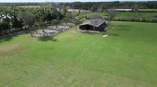 an aerial view of a house with swimming pool garden and patio