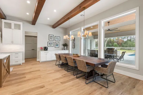 a dining room with furniture a chandelier and wooden floor