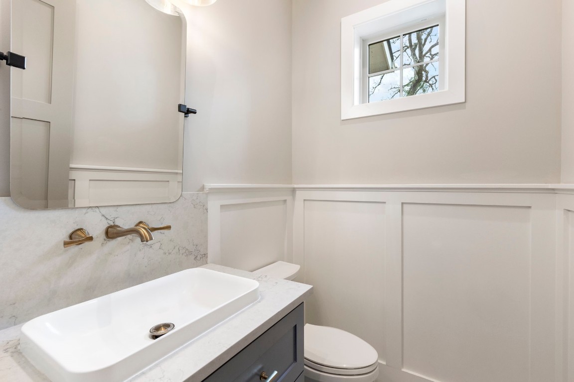 27318 Blue Cedar Lane Spring, TX 77386 - Photo 17 of 45 Powder bath with crisp wainscoting, marble-look vanity top, and warm brass wall-mounted faucet.