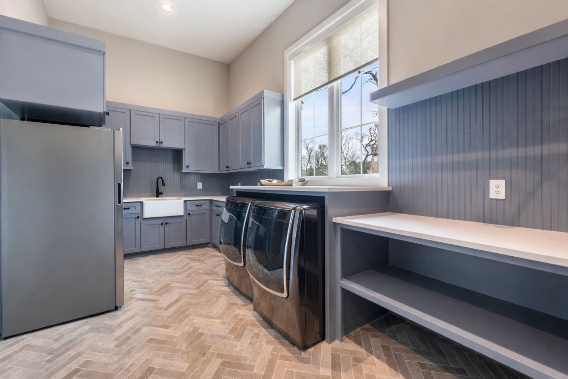 27318 Blue Cedar Lane Spring, TX 77386 - Photo 21 of 45 Bright laundry room with shaker cabinetry, farmhouse sink, beadboard walls, and herringbone tile flooring.