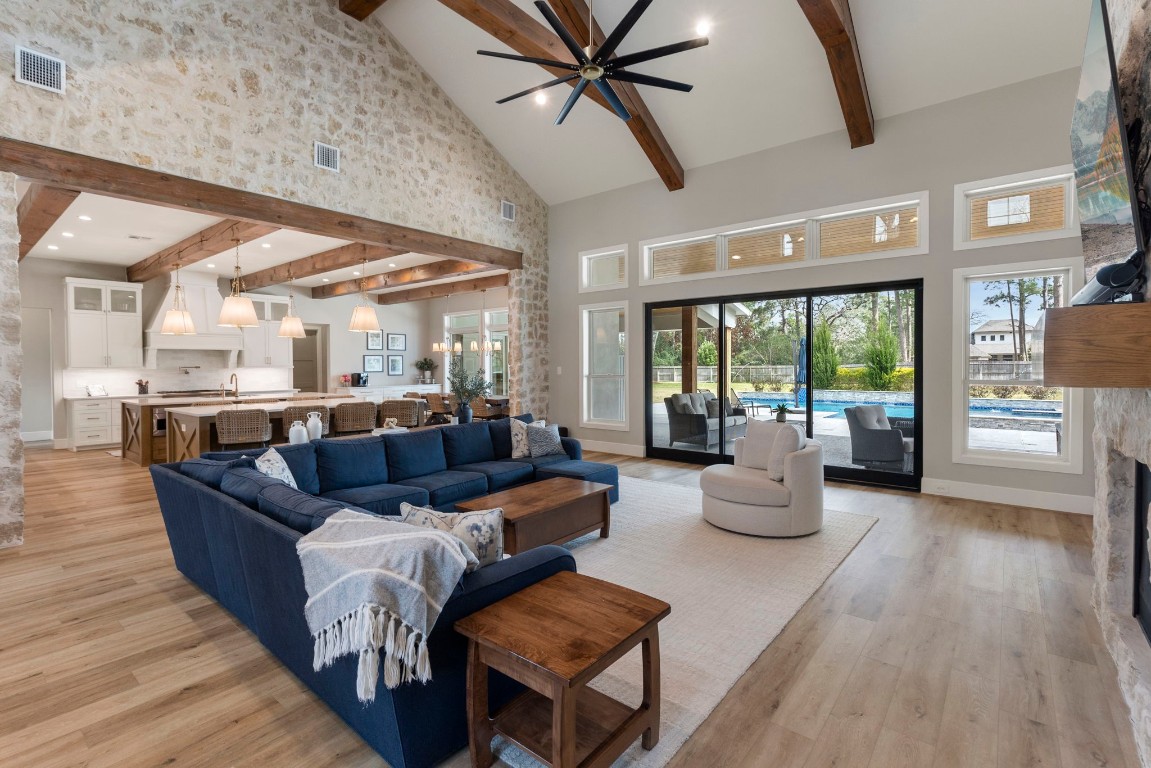 27318 Blue Cedar Lane Spring, TX 77386 - Photo 6 of 45 Vaulted beamed ceilings and stone accents anchor this open living area with walls of windows.