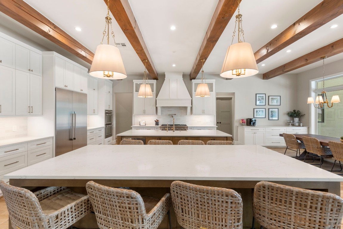 27318 Blue Cedar Lane Spring, TX 77386 - Photo 8 of 45 Chef’s kitchen shines with exposed beams, oversized island, custom cabinetry, and statement range hood.
