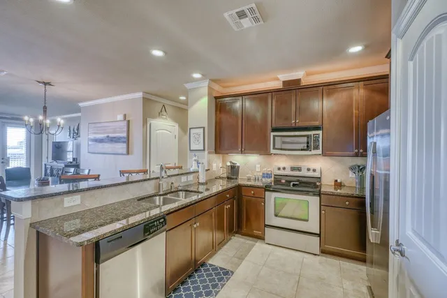 a kitchen with stainless steel appliances kitchen island granite countertop a sink and cabinets
