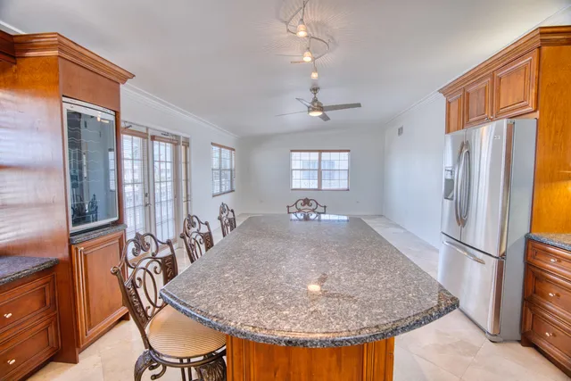 an empty room with a kitchen view and a large window