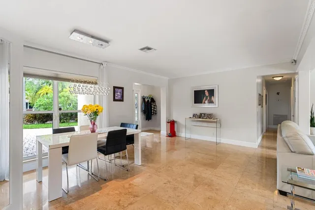 a living room with furniture a large window and stainless steel appliances