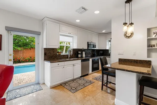 a kitchen with a refrigerator and white cabinets