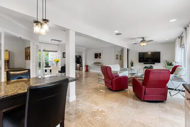 a large living room with furniture a flat screen tv and kitchen view