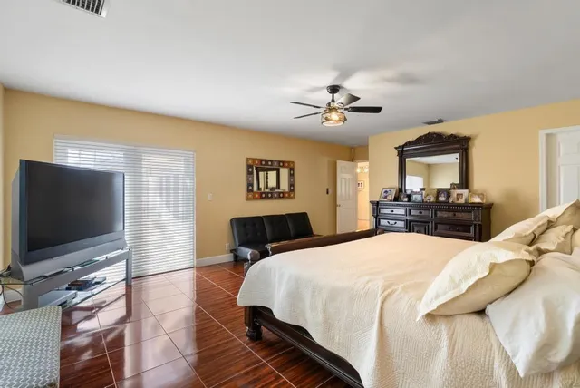 a bedroom with a bed and a flat screen tv on dresser