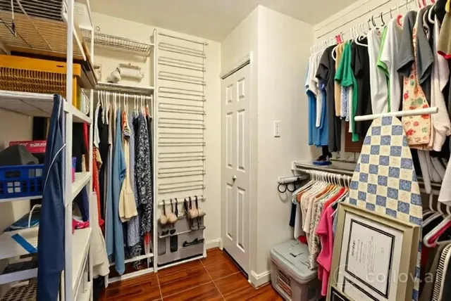 a view of walk in closet with clothes and shoes
