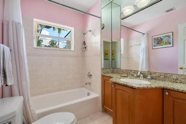 a bathroom with a granite countertop tub sink and mirror
