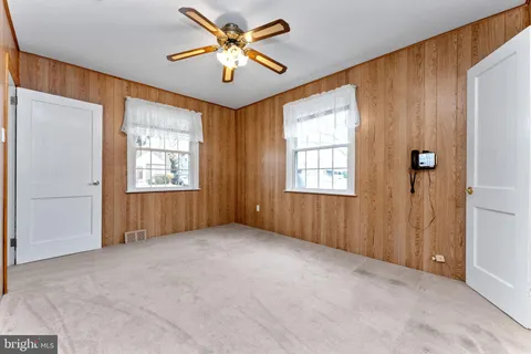 an empty room with closet and windows