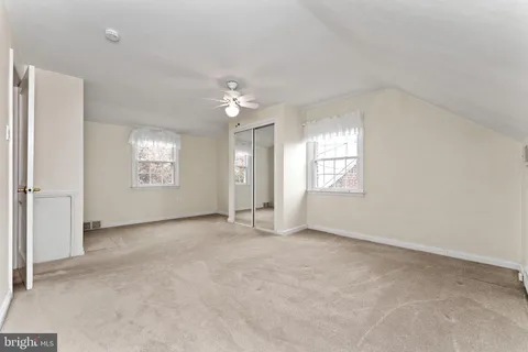 an empty room with chandelier fan