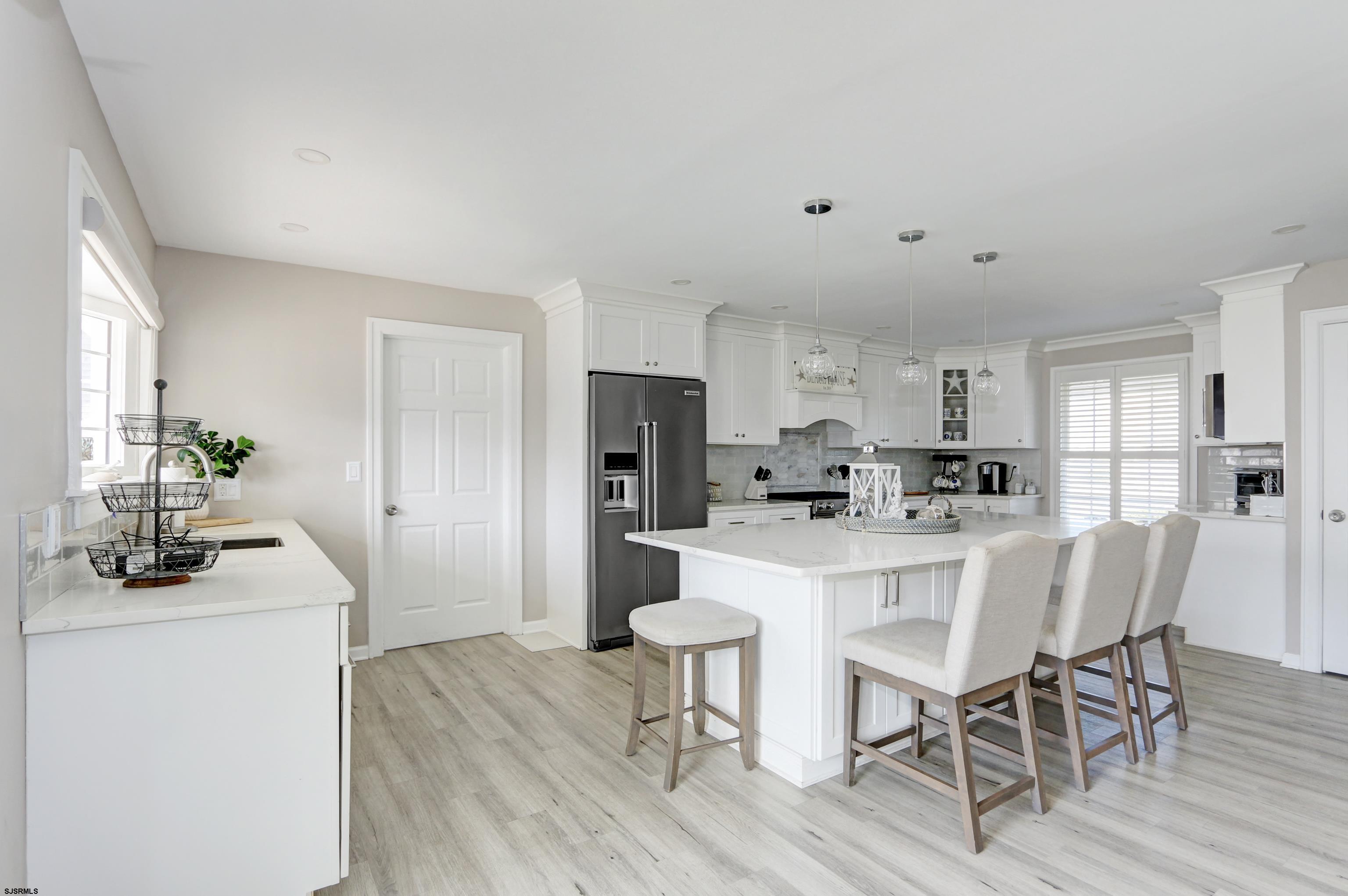 9 Sunset Boulevard Egg Harbor Township, NJ 08403 - Photo 8 of 60 a kitchen with a dining table chairs refrigerator and cabinets