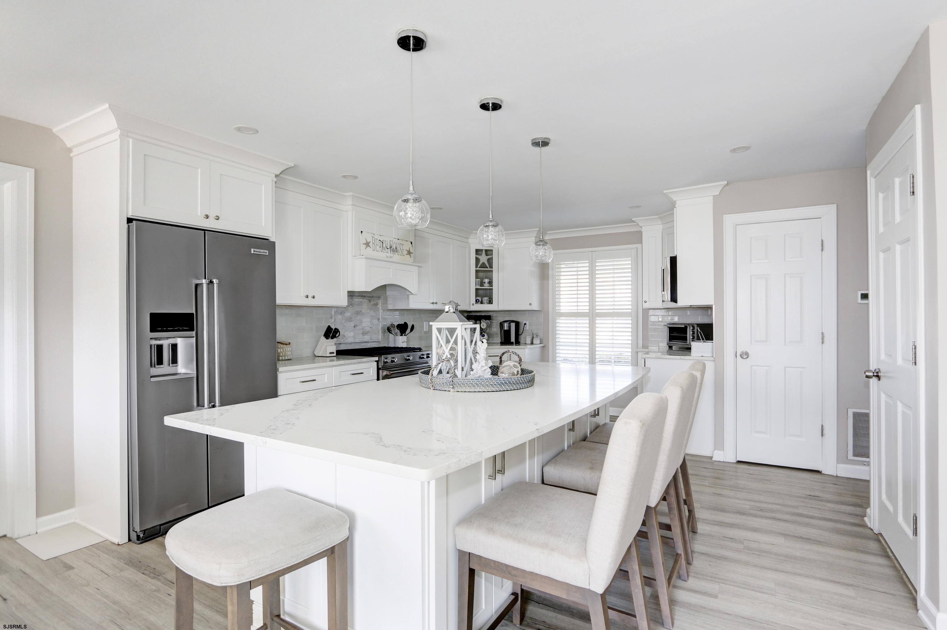 9 Sunset Boulevard Egg Harbor Township, NJ 08403 - Photo 9 of 60 a kitchen with stainless steel appliances a refrigerator a stove a dining table and chairs