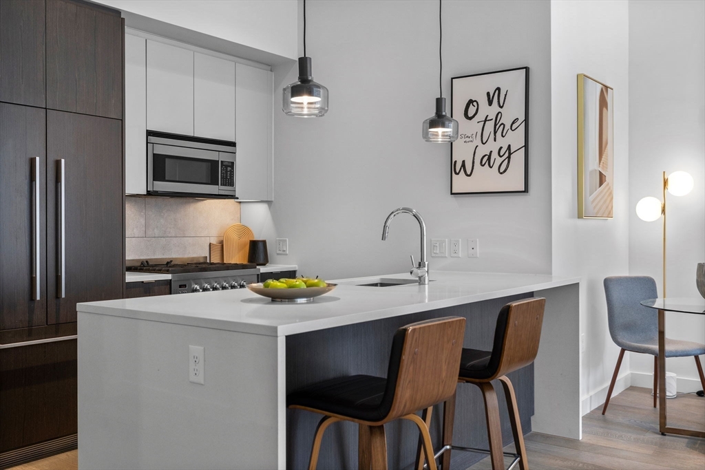 375 Canal Street, Unit PH101 Somerville, MA 02145 - Photo 11 of 39 a kitchen with a table chairs refrigerator and microwave